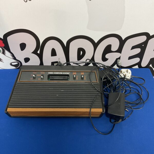 Vintage Atari 2600 console with woodgrain finish and joystick.