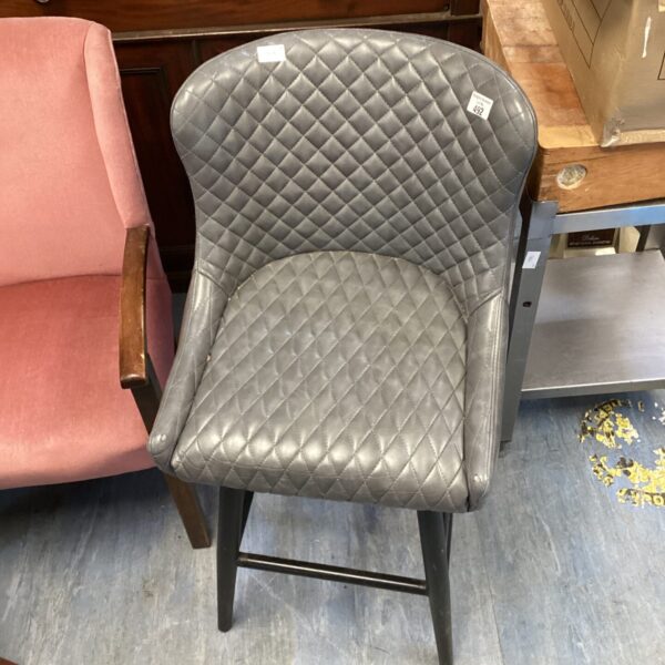 Grey Dunelm leather stool with quilted padding and wooden legs.