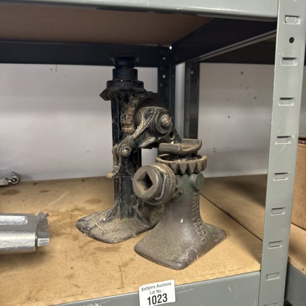 Side view of a vintage car jack, showing its cast iron construction.