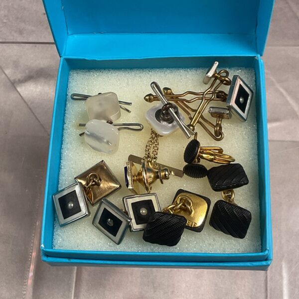 Vintage cufflinks and tie pin lot on display.