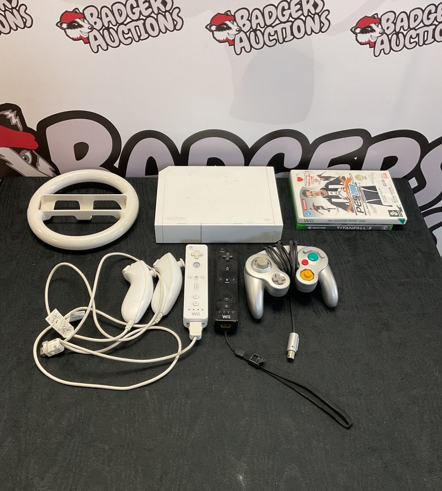 Nintendo wii console with cables, two controllers, one gamecube controller and pro evolution soccer game