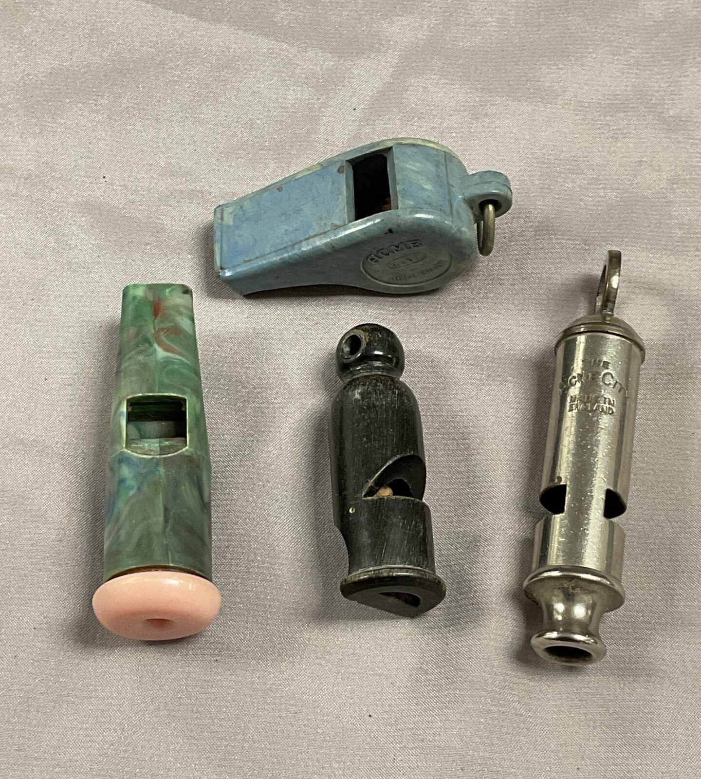 Three vintage Bakelite whistles and acme city whistle