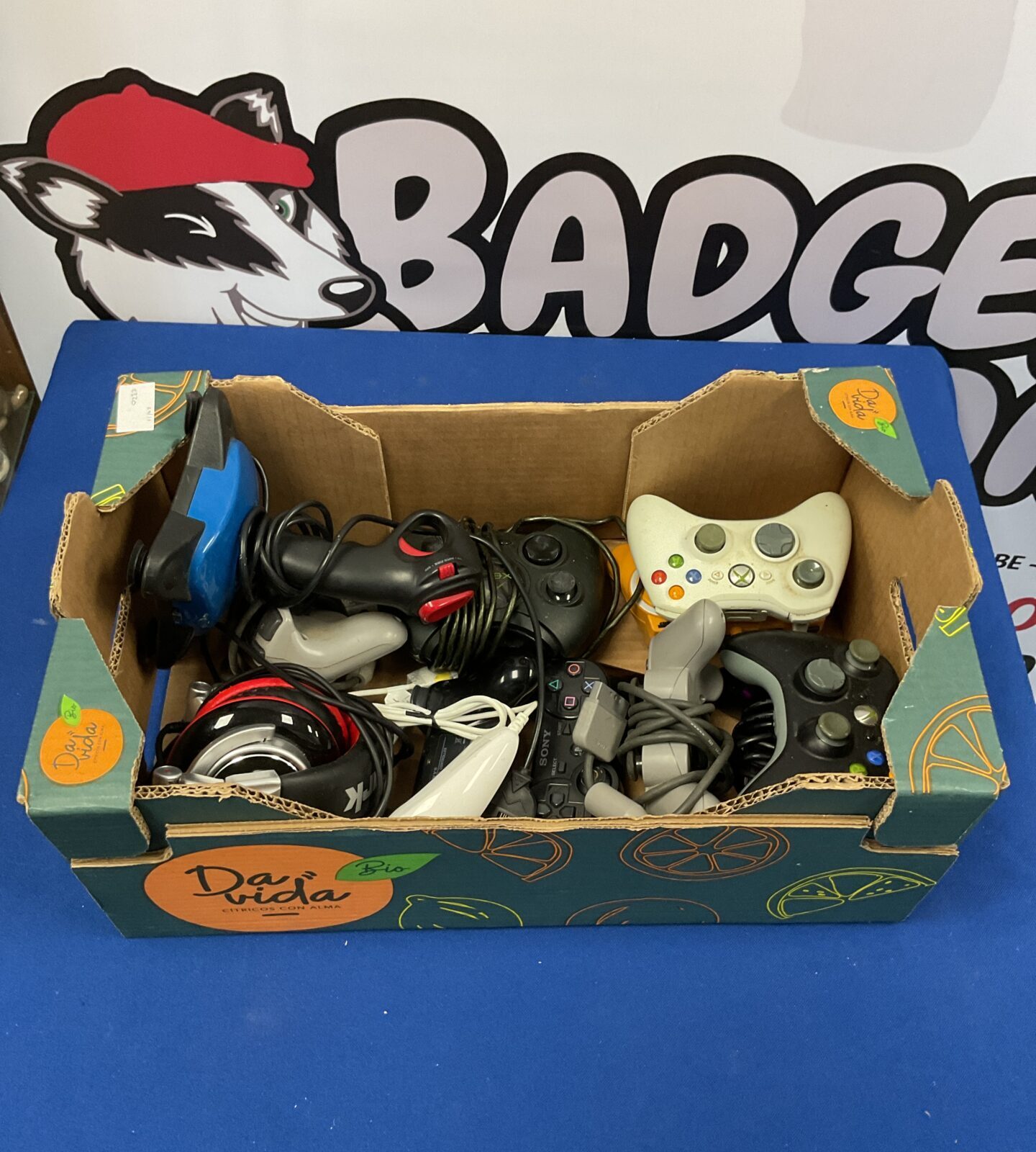 Collection of various controllers including Xbox, PlayStation a joystick and a pair of headphones