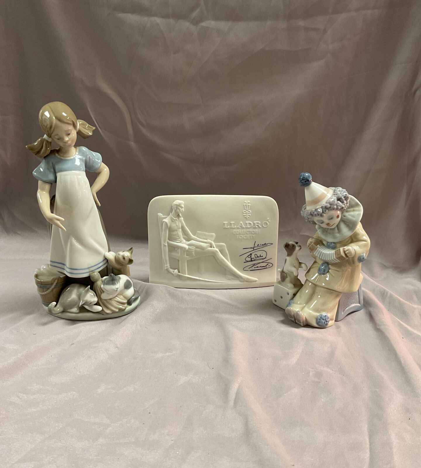 Three Lladro figures, girl with cats a clown with puppy and collectors plaque