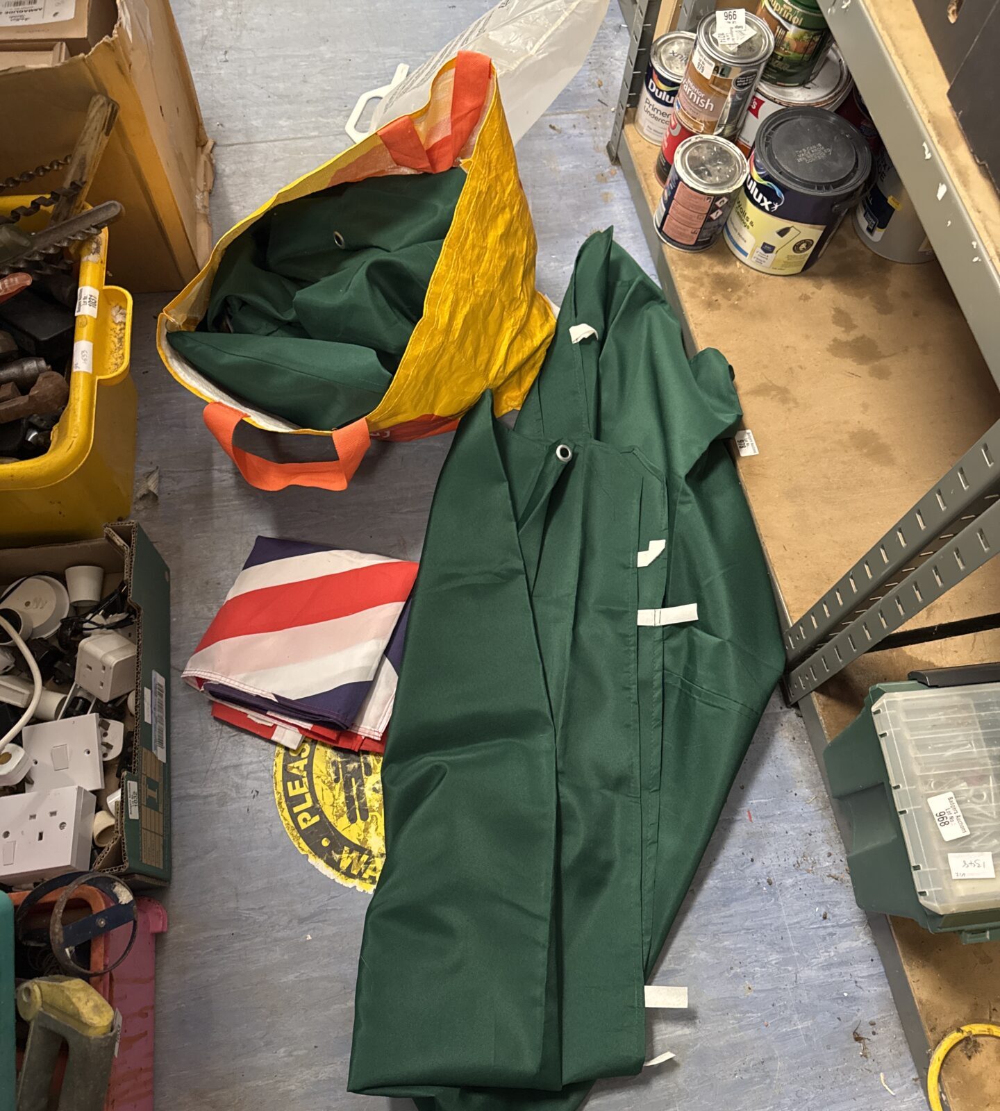 Bag of green sheets (possibly part of a canopy) with a large Union Jack flag