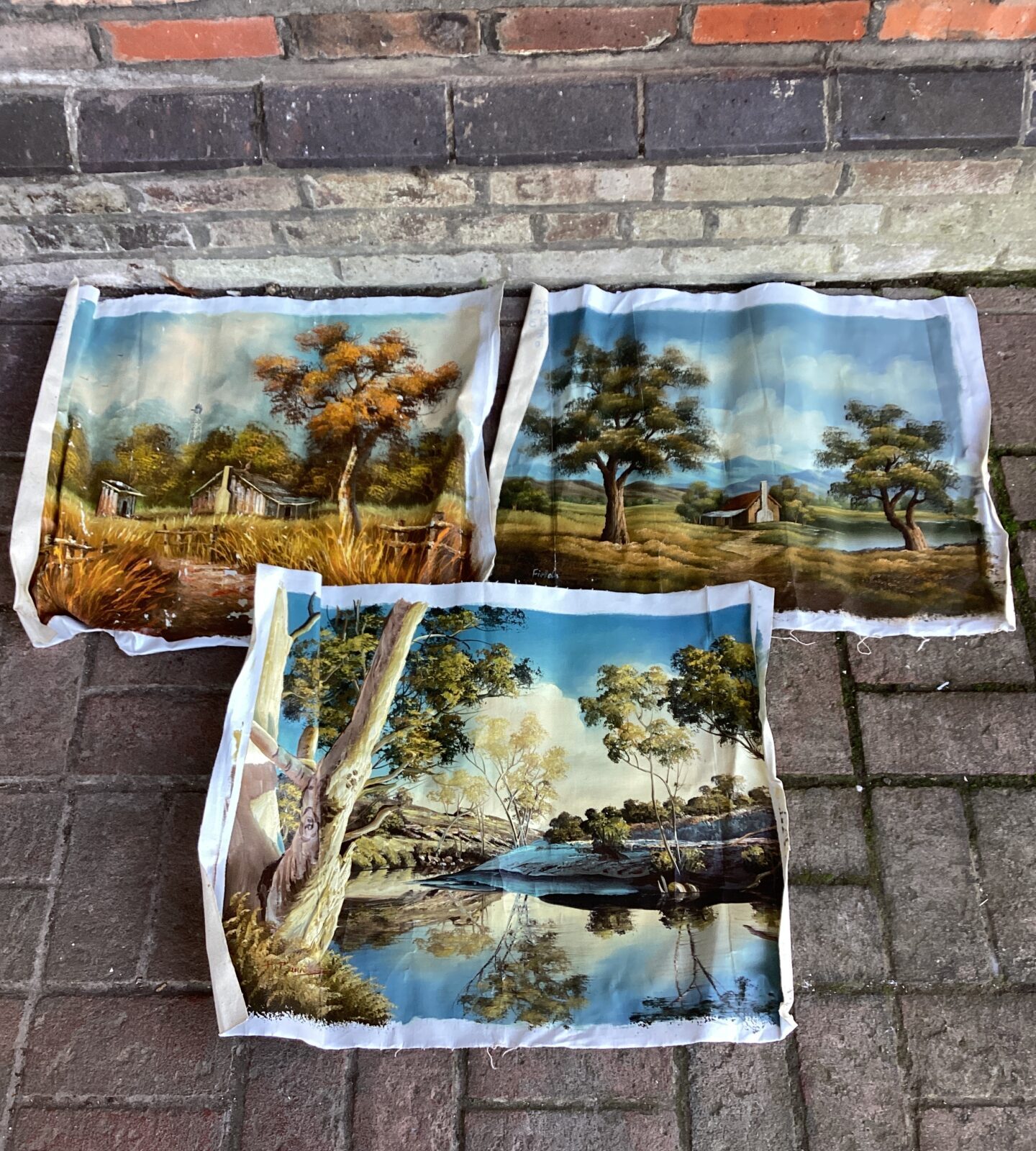 three unframed oil on canvas paintings of country landscapes