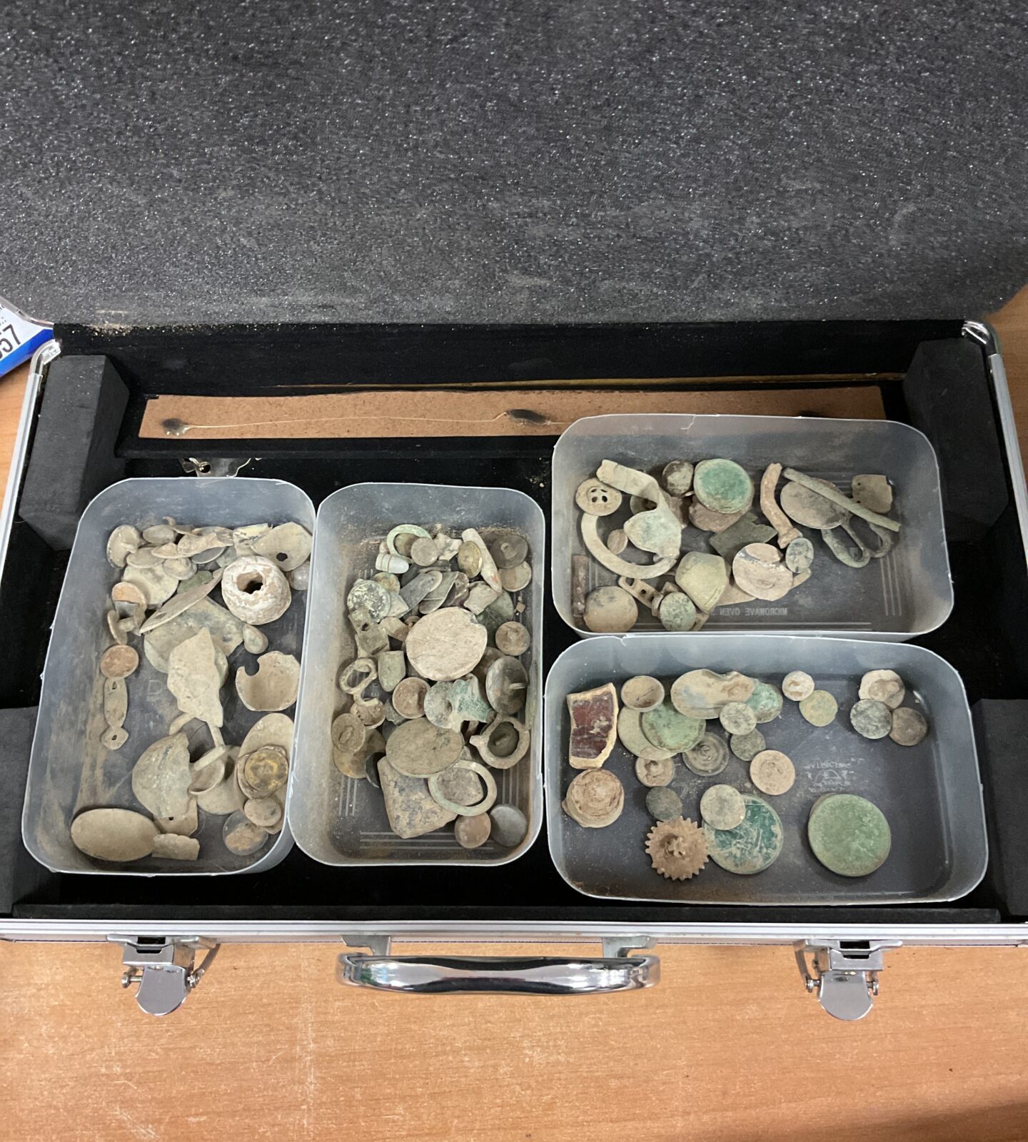 aluminium case with trays of metal detector finds including coins