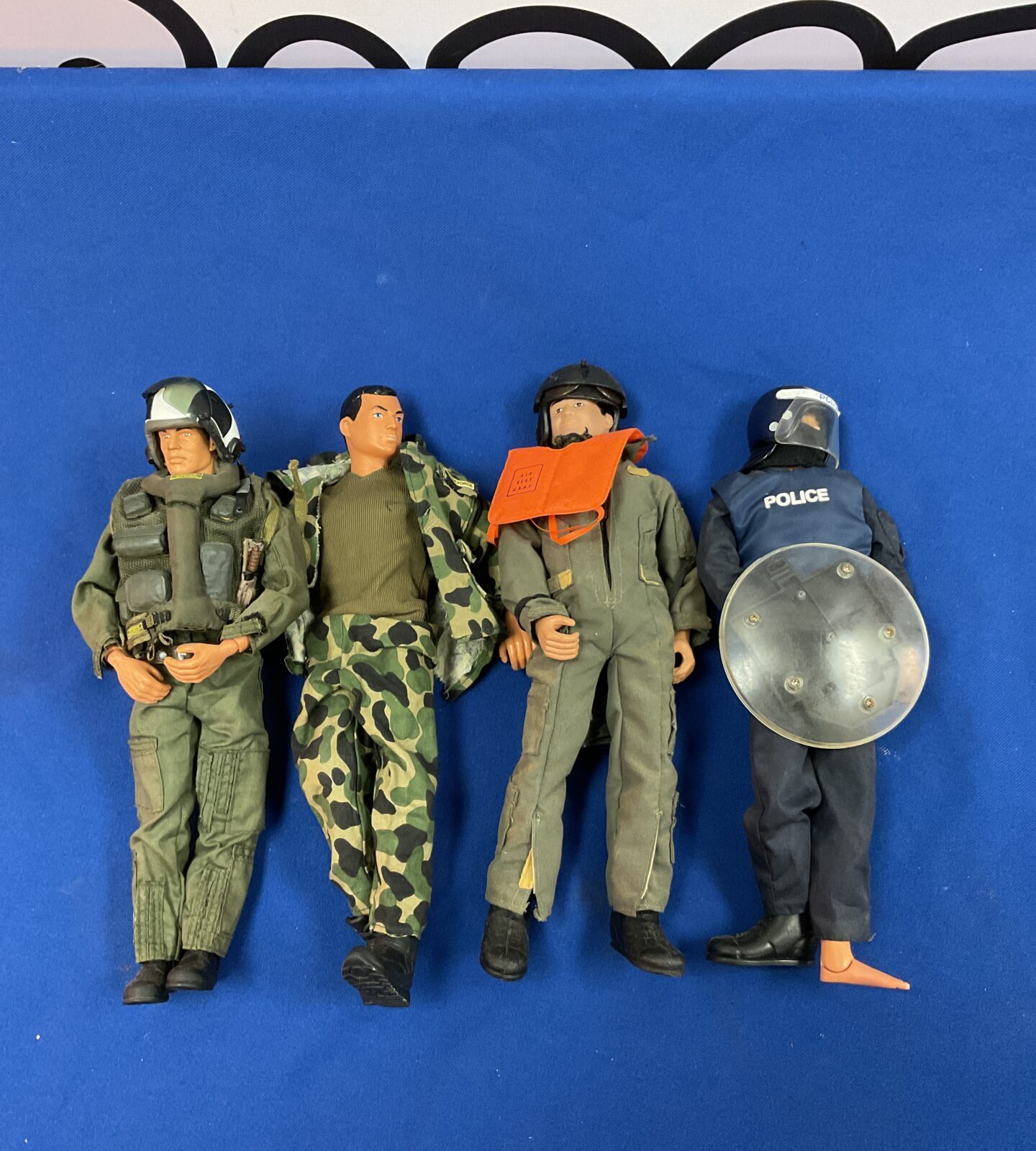 Four action figures including m&c police riot figure