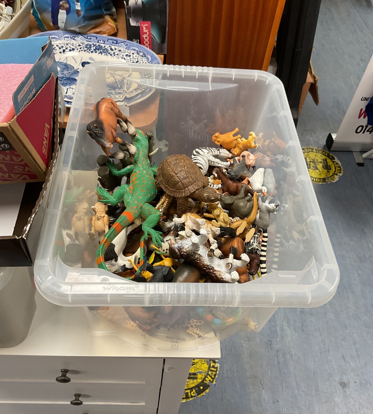 Box full of farm animals and dinosaurs