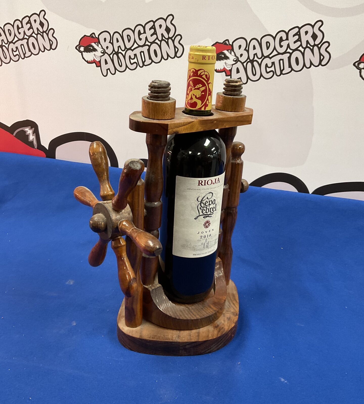 Wooden ships wheel wine pourer with bottle of Rioja