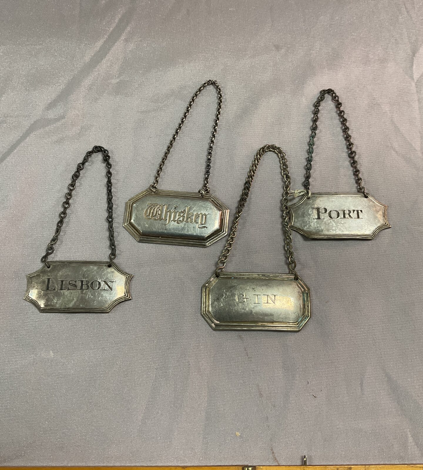 Four silver plate spirit tags one marked lisbon