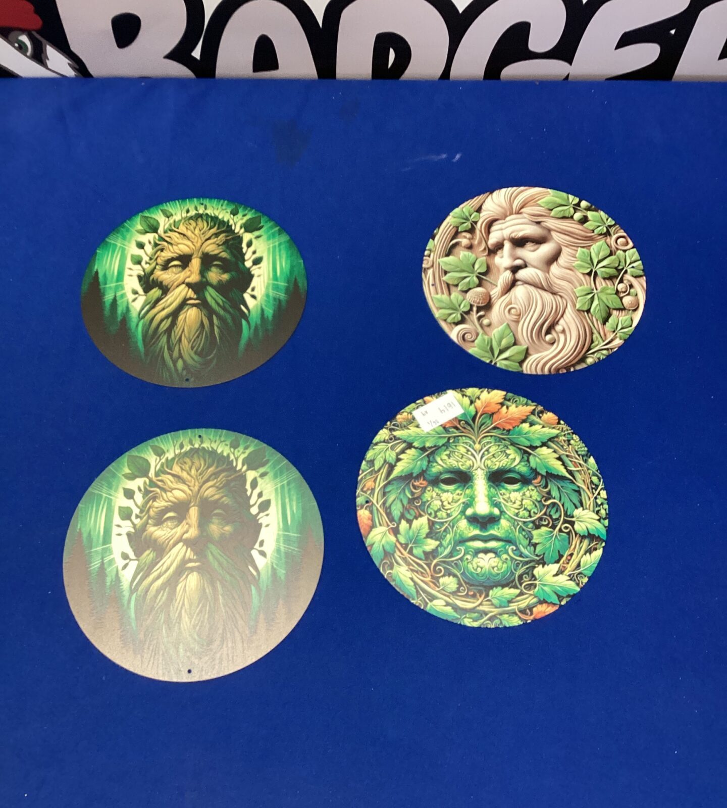 Four circular green-man tin signs