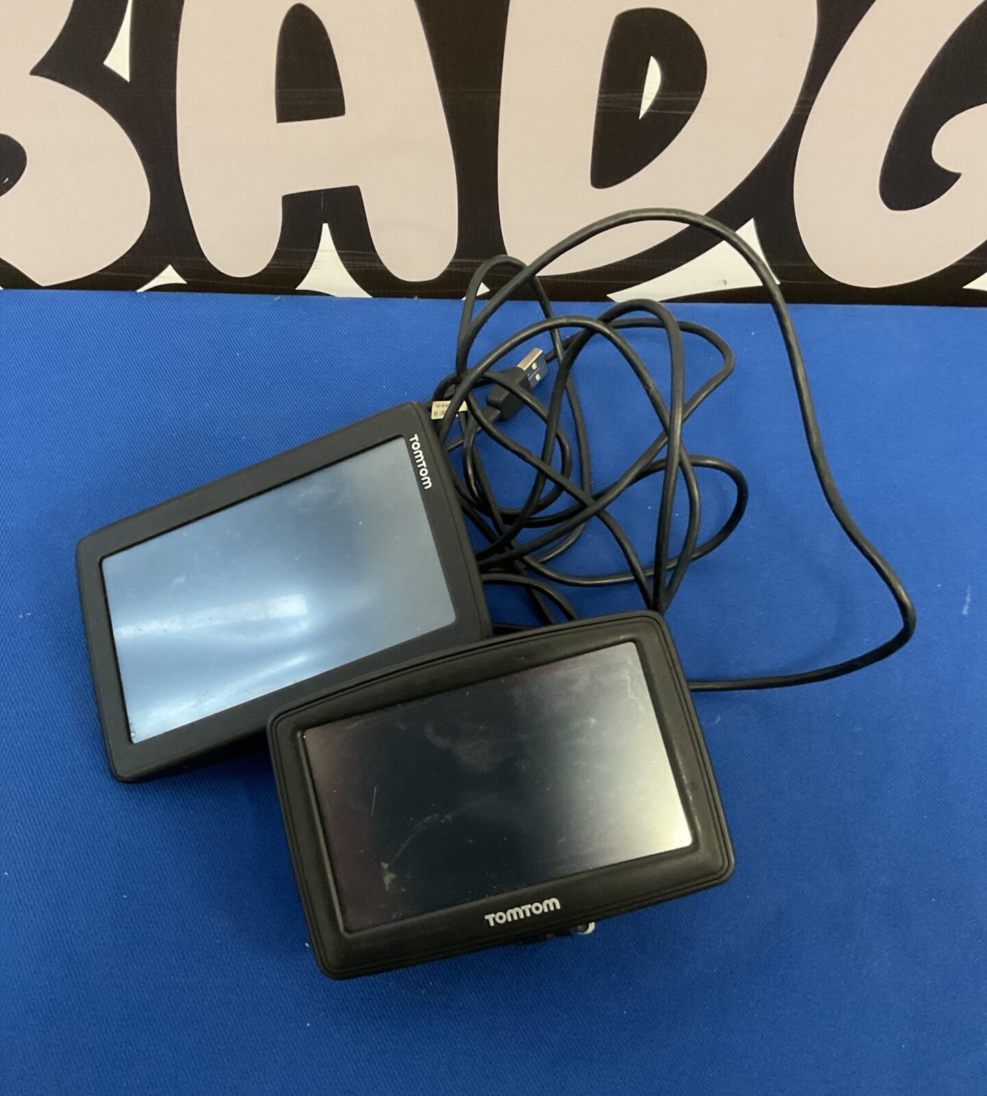 Two tomtom sat navs with cables