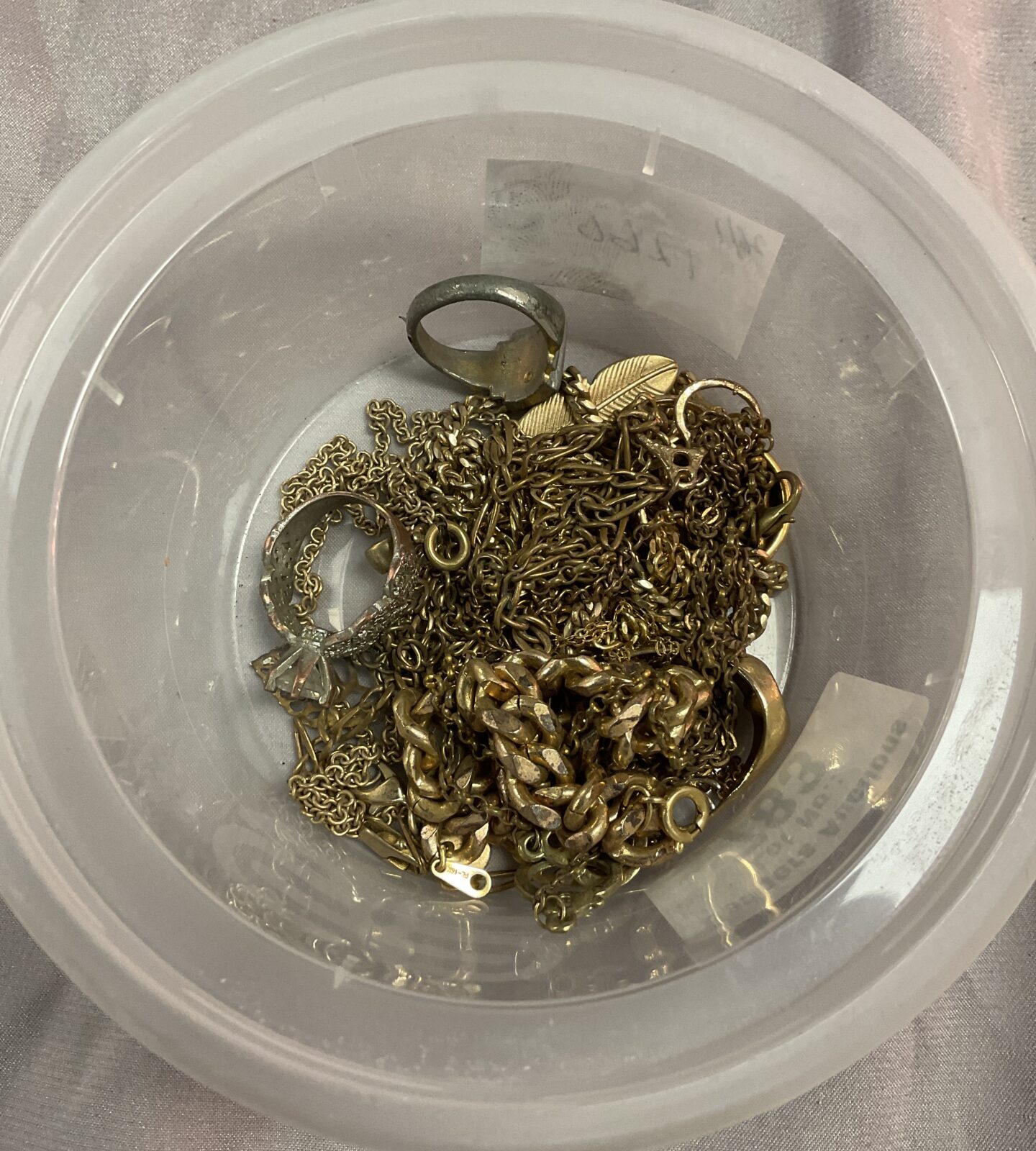 Tub of yellow metal jewellery