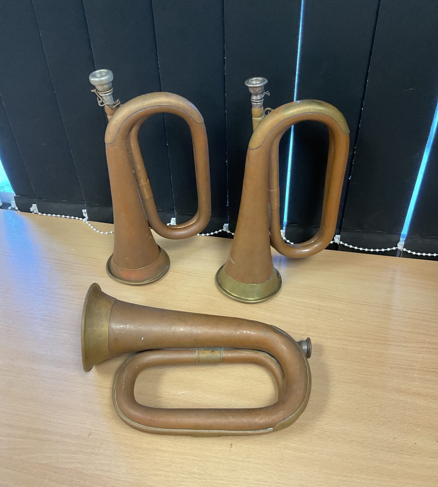 Three vintage copper bugle horns including boosey & hawkes & john e dallas & sons