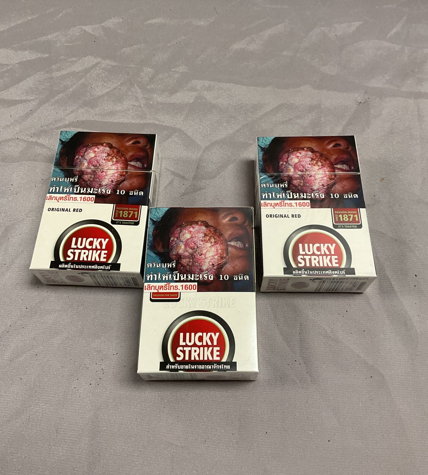 three packs of lucky strike cigarettes