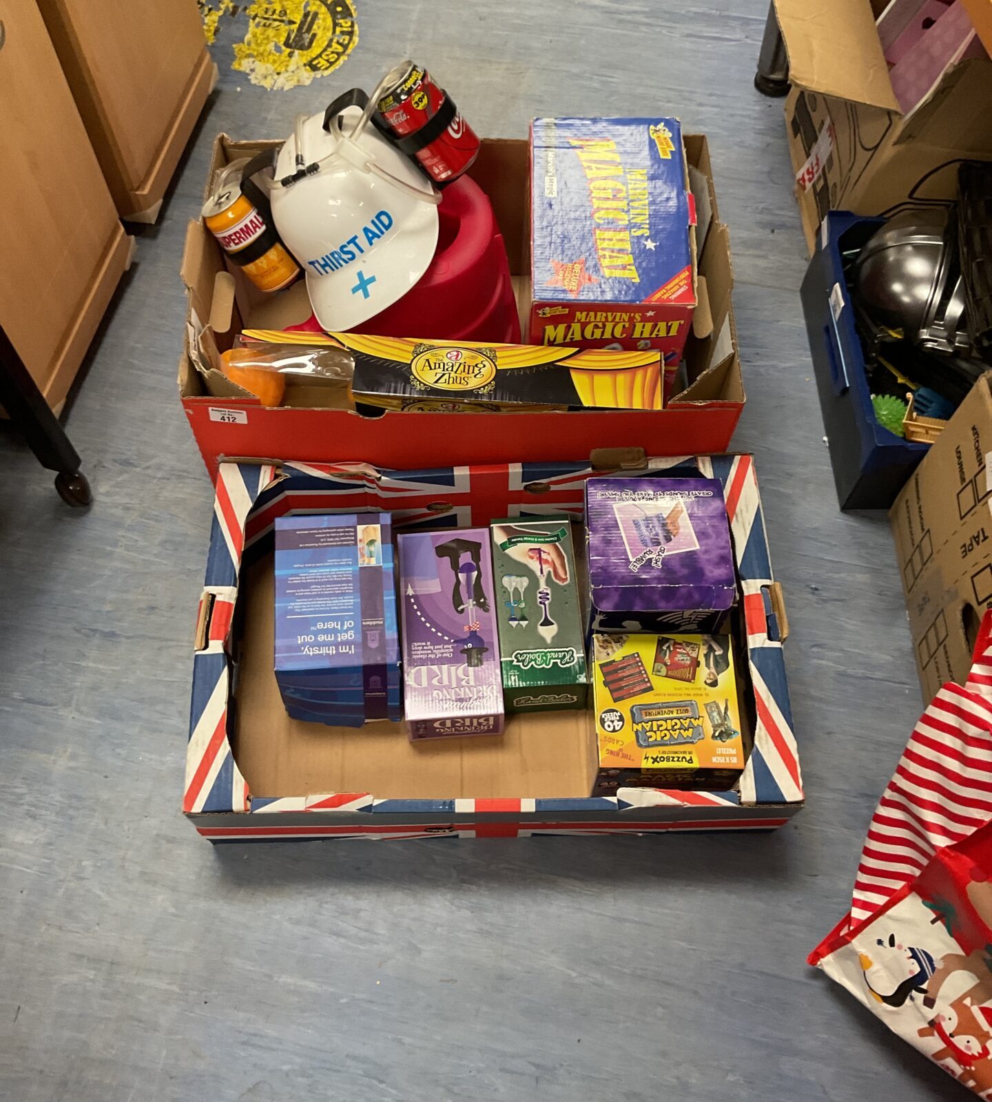 Two boxes of mixed inc thirst aid drinking hat, marvins magic hat and other toys