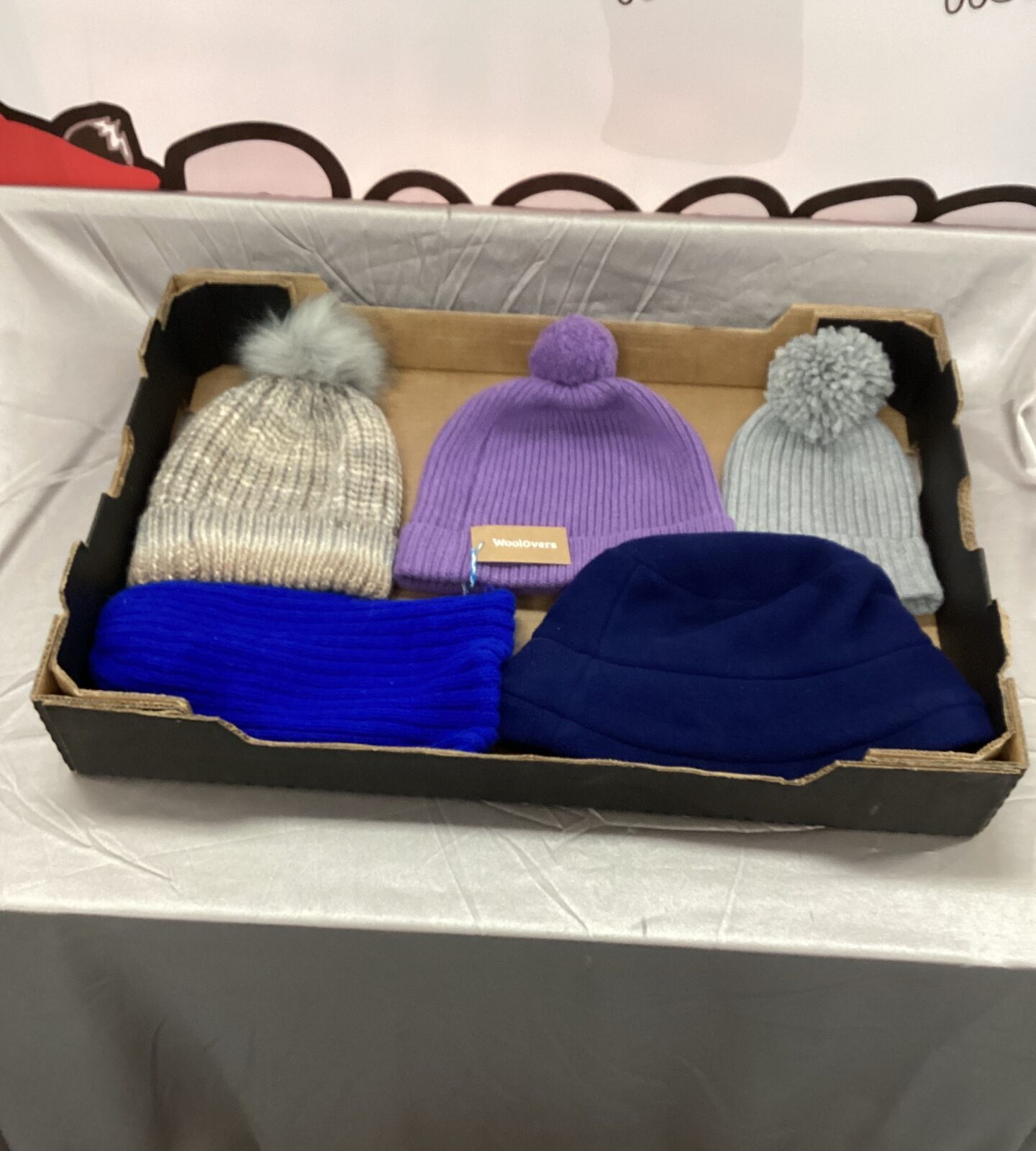 tray of ladies woolen bobble hats