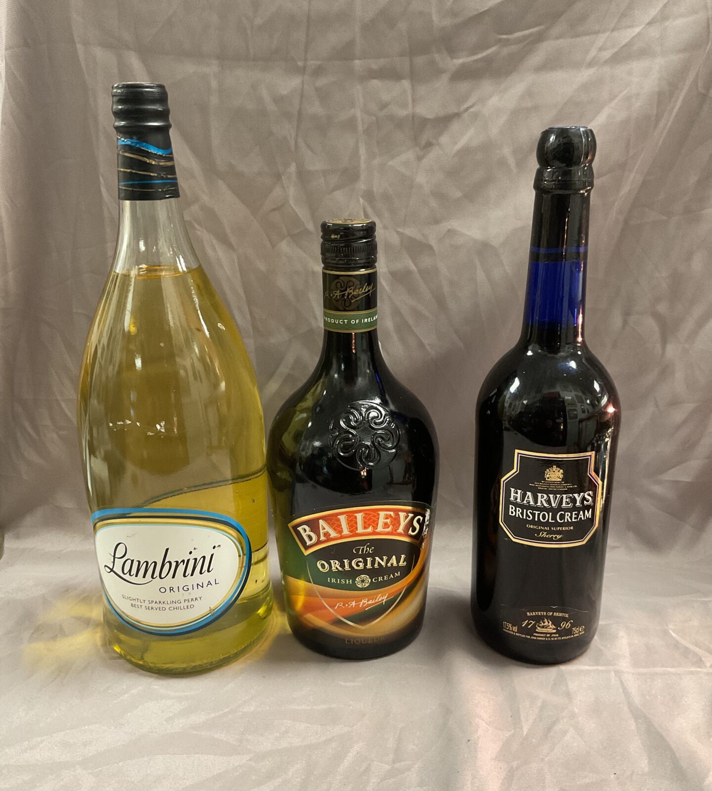 bottle of lambrini, baileys original and harveys bristol cream sherry