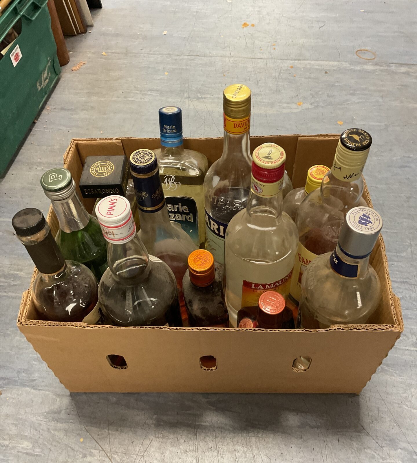 Box of mixed opened bottles of alcohol including