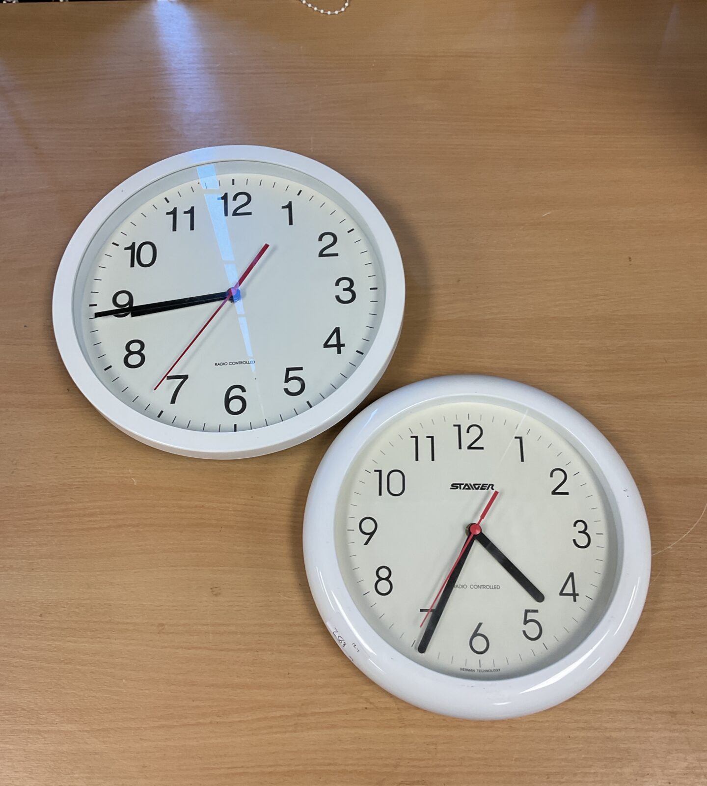 Two radio controlled wall clocks including staiger