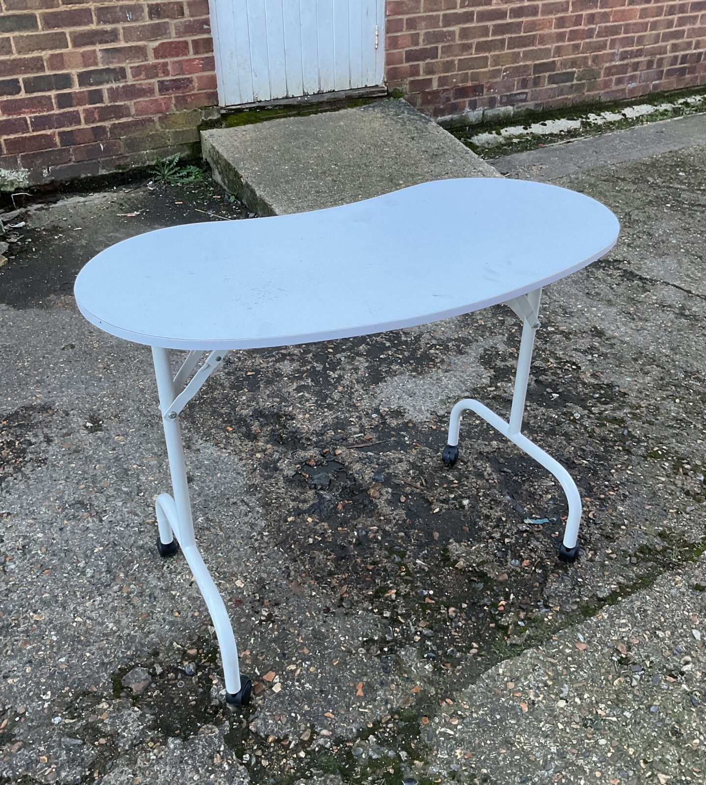 White folding kidney table on wheels