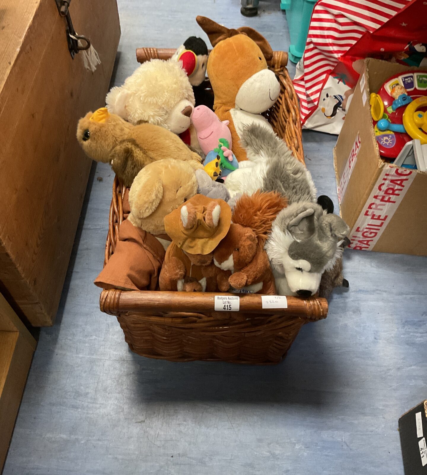 Wicker basket containing mixed soft toys and teddies