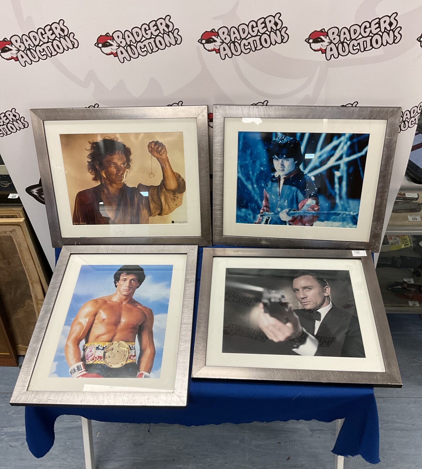 Four framed movie photographic prints including james bond, lord of the rings & rocky