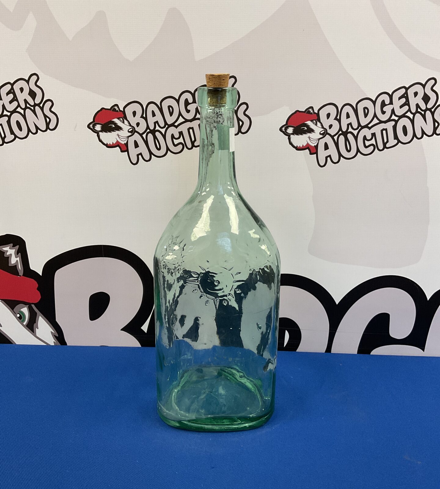 Green glass bottle with sun pattern