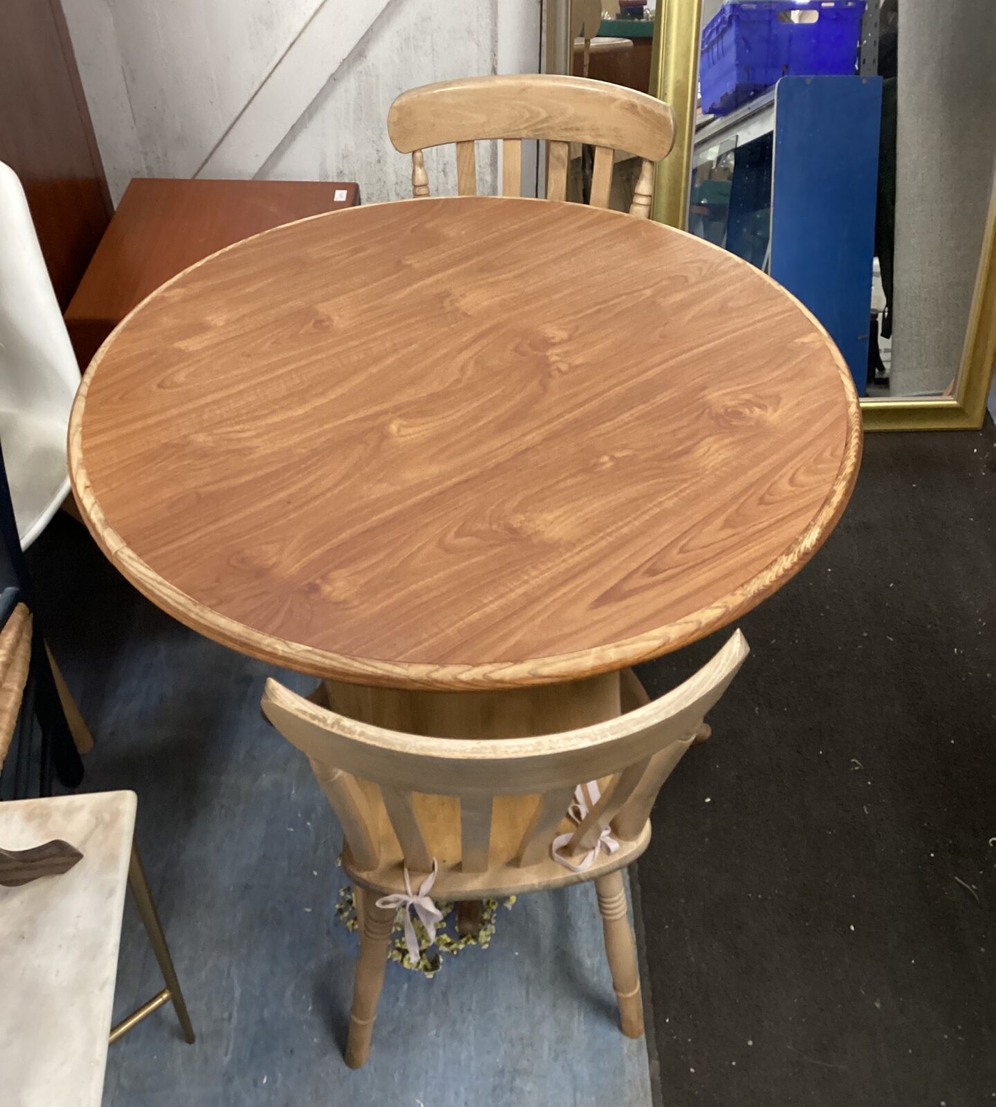 Round wooden dining table with two chairs