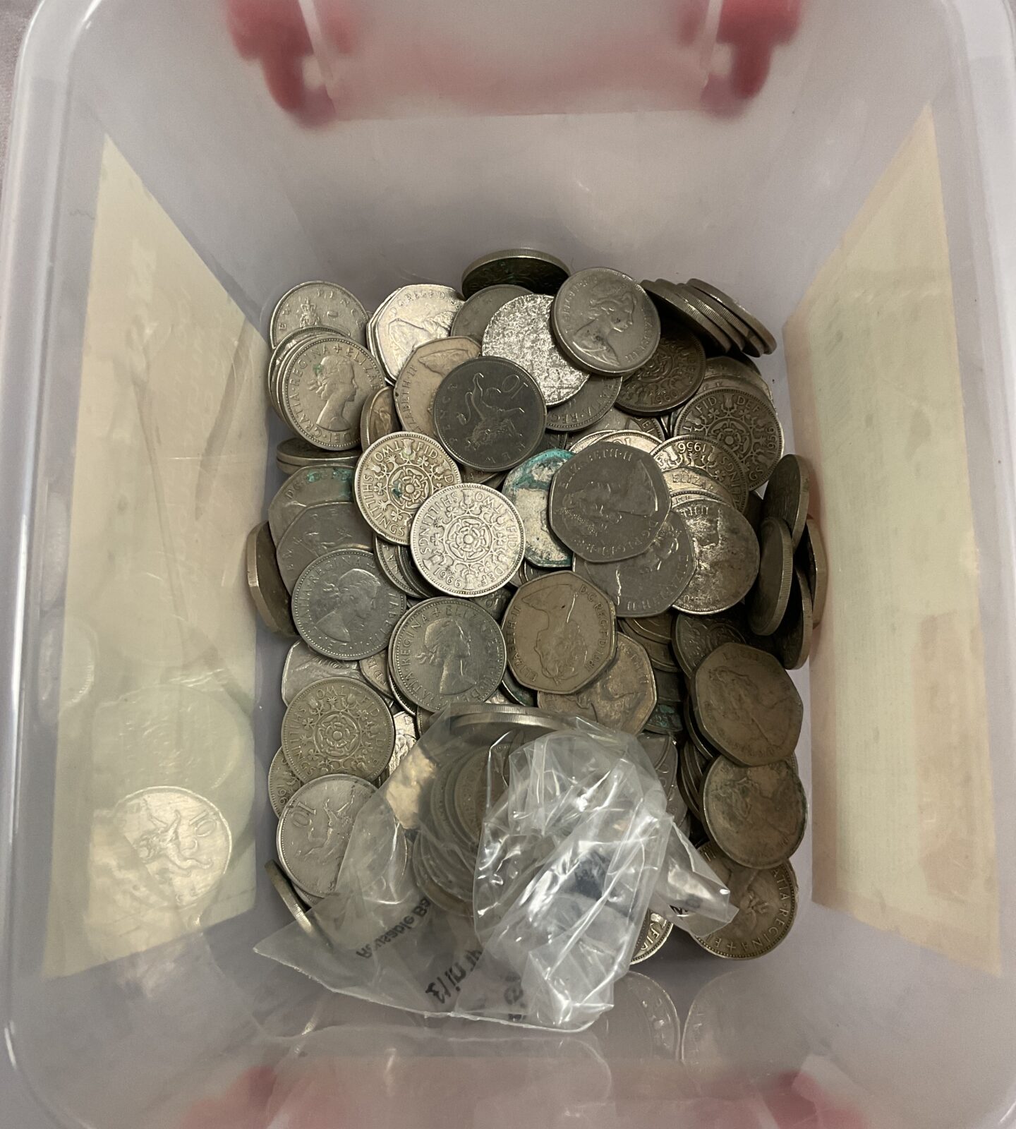 Tub of 50p and two shillings coins