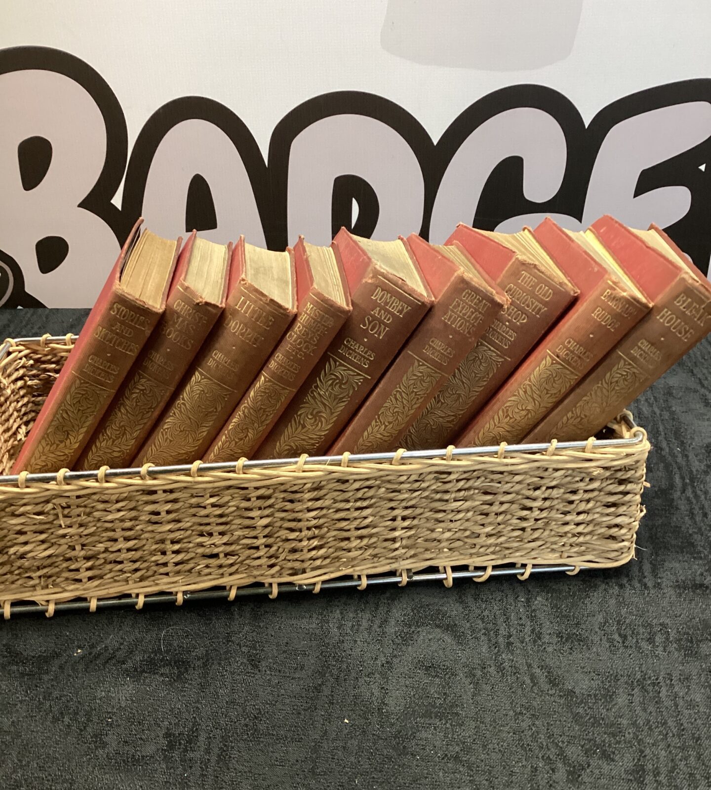 Vintage selection of Charles dickens books in wicker basket