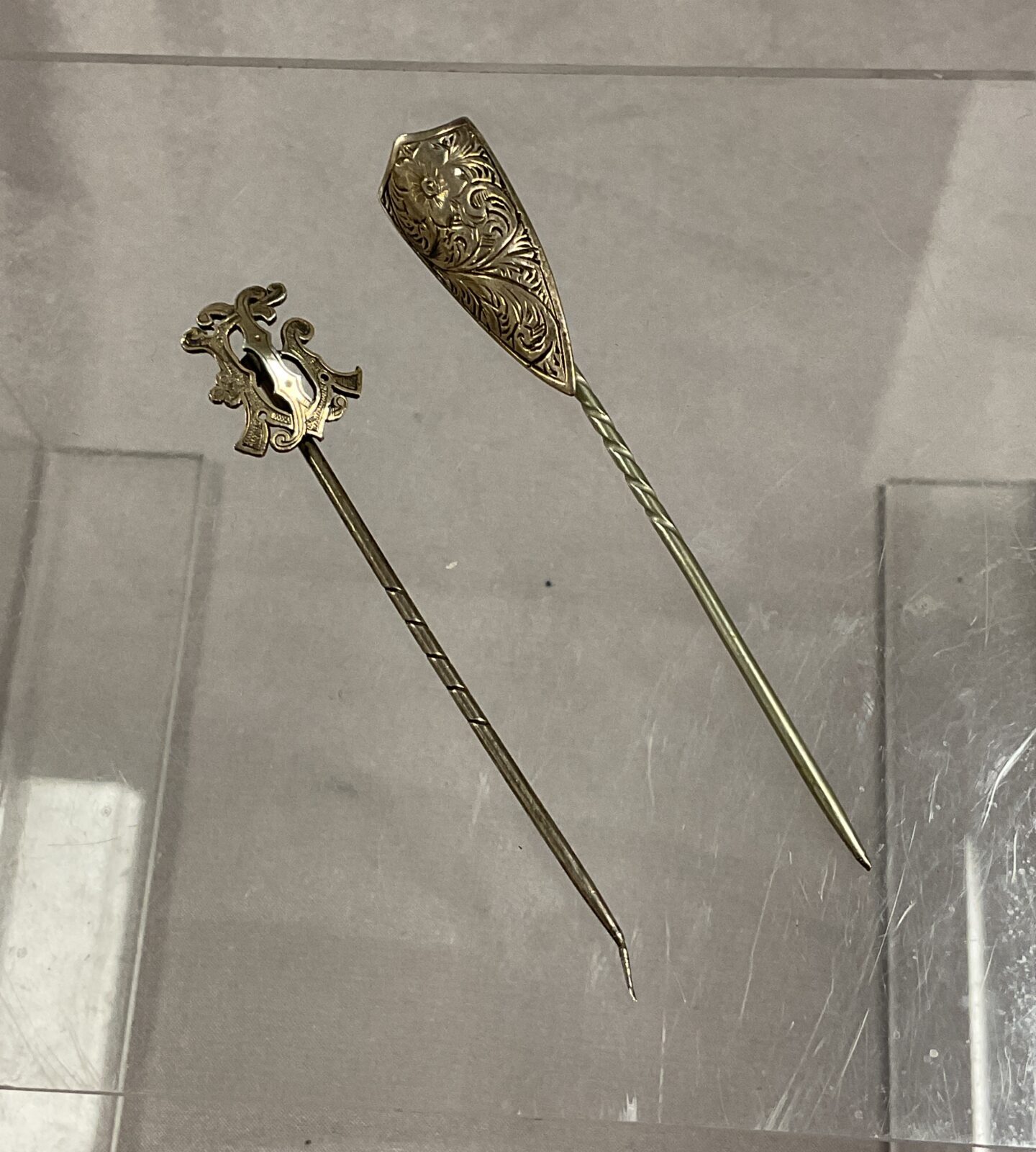 Two white metal stick pins