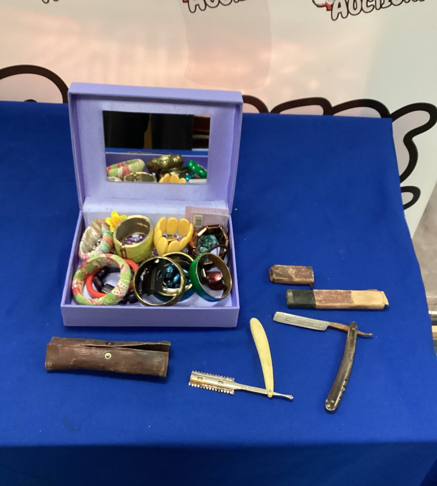 Box of costume jewellery with two razors