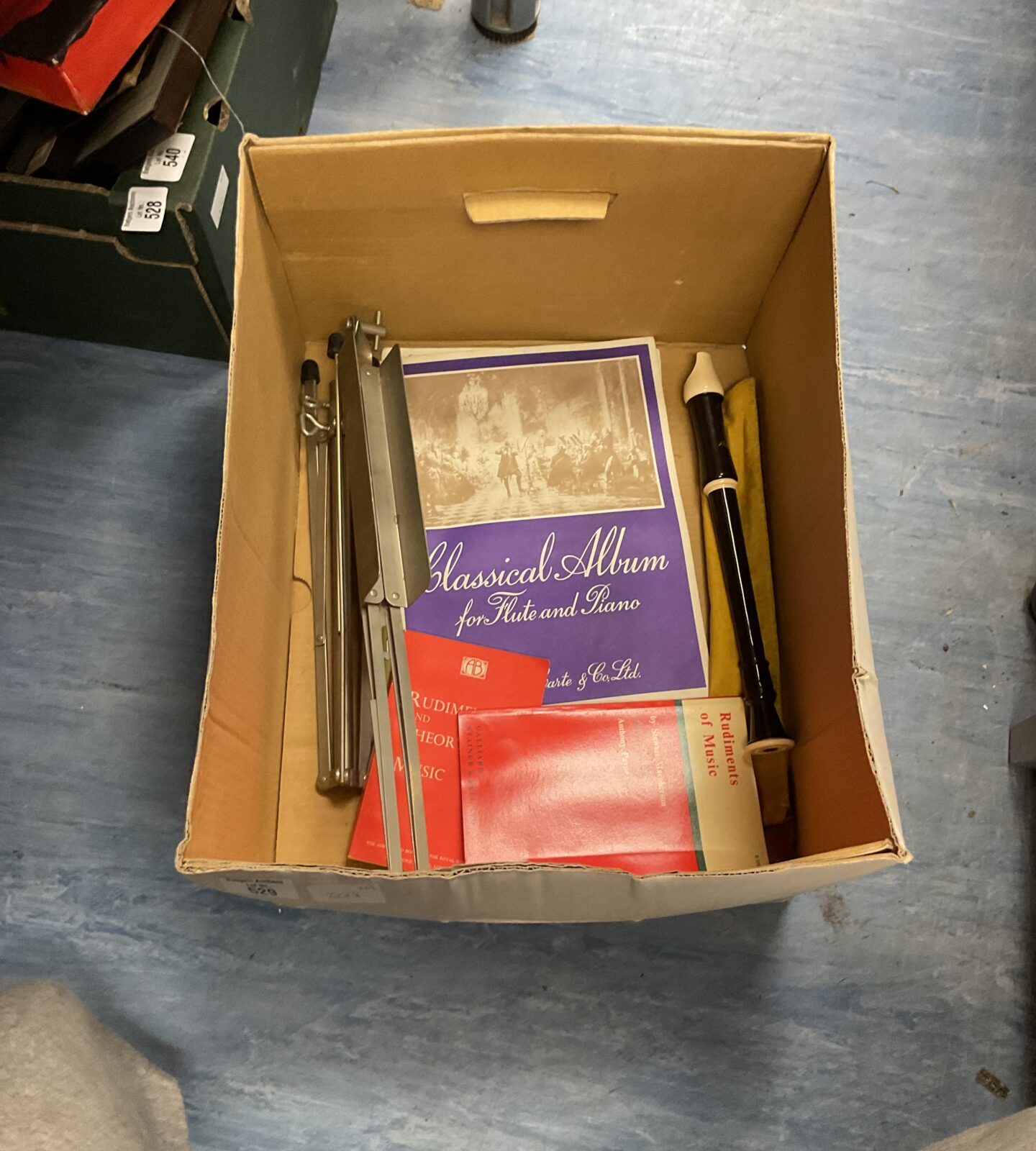 Box of sheet music with recorder and stand