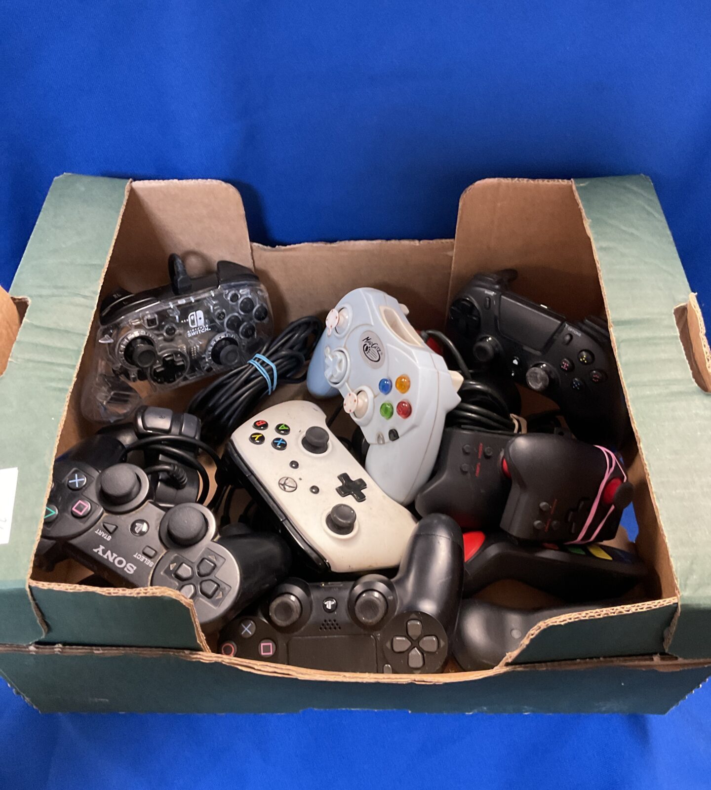 Box of gaming controllers inc Nintendo switch & sony ps3