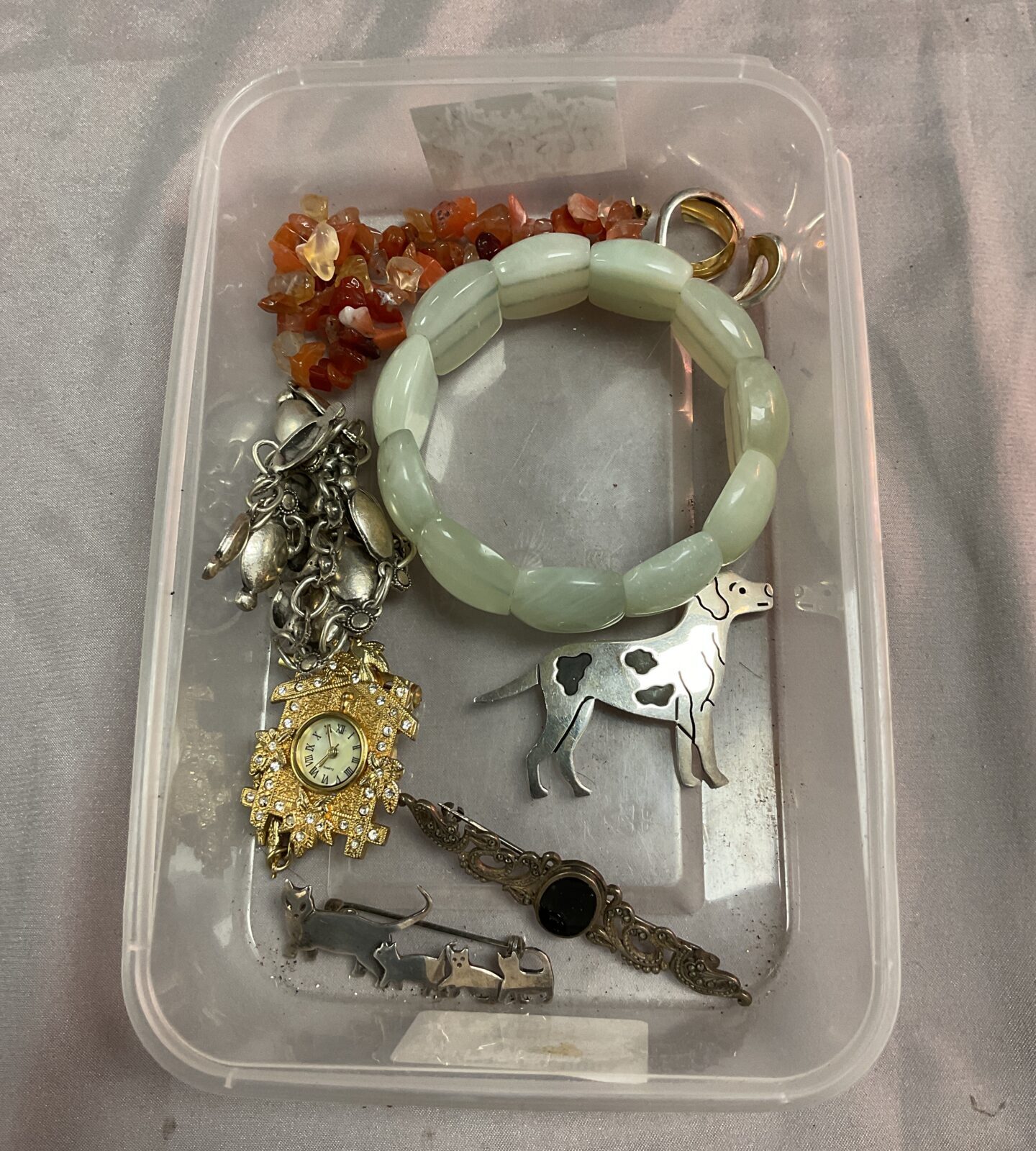 Tray of bracelets inc jade, amber and silver brooches
