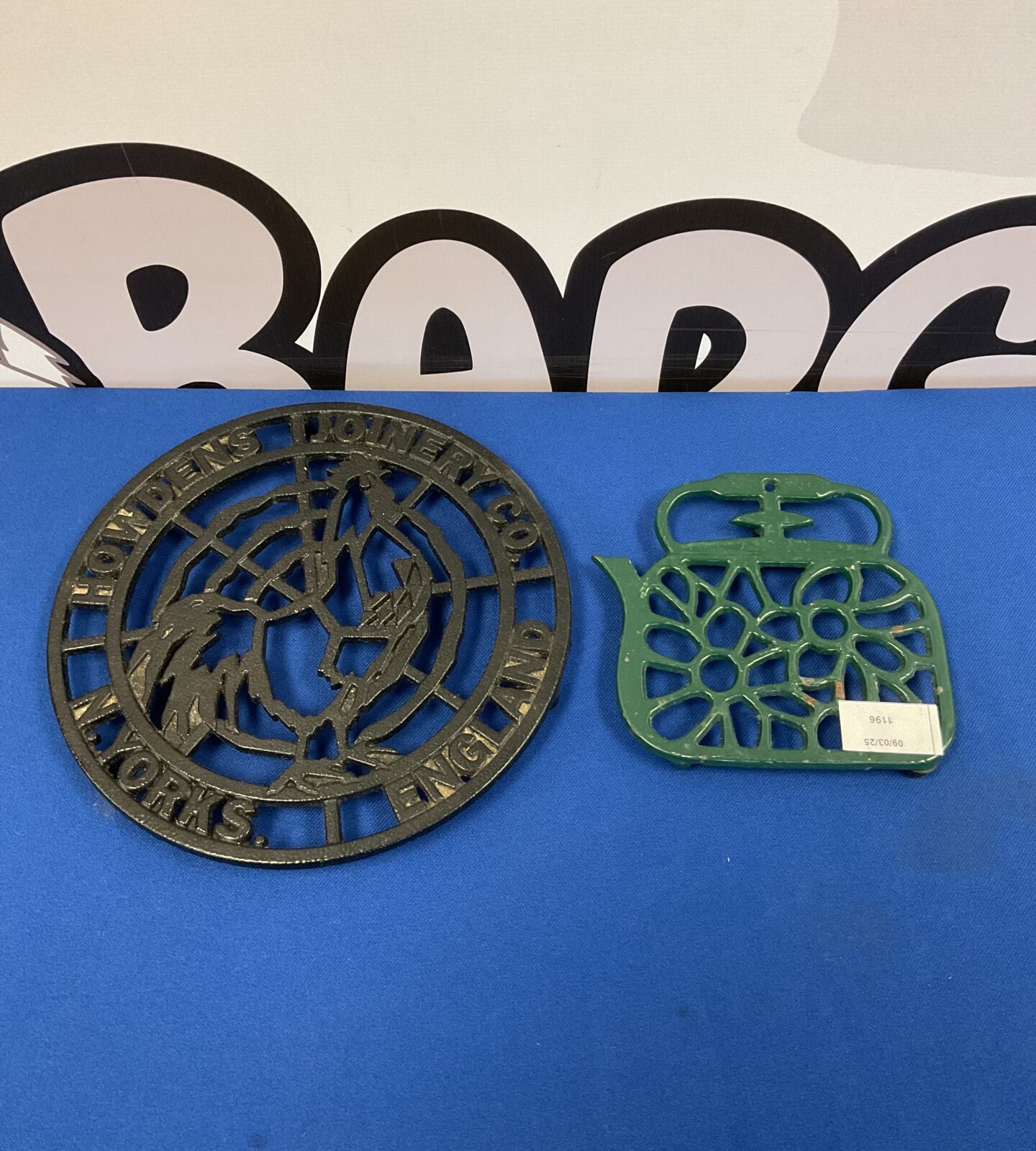 Two cast iron trivets including howdens joinery co