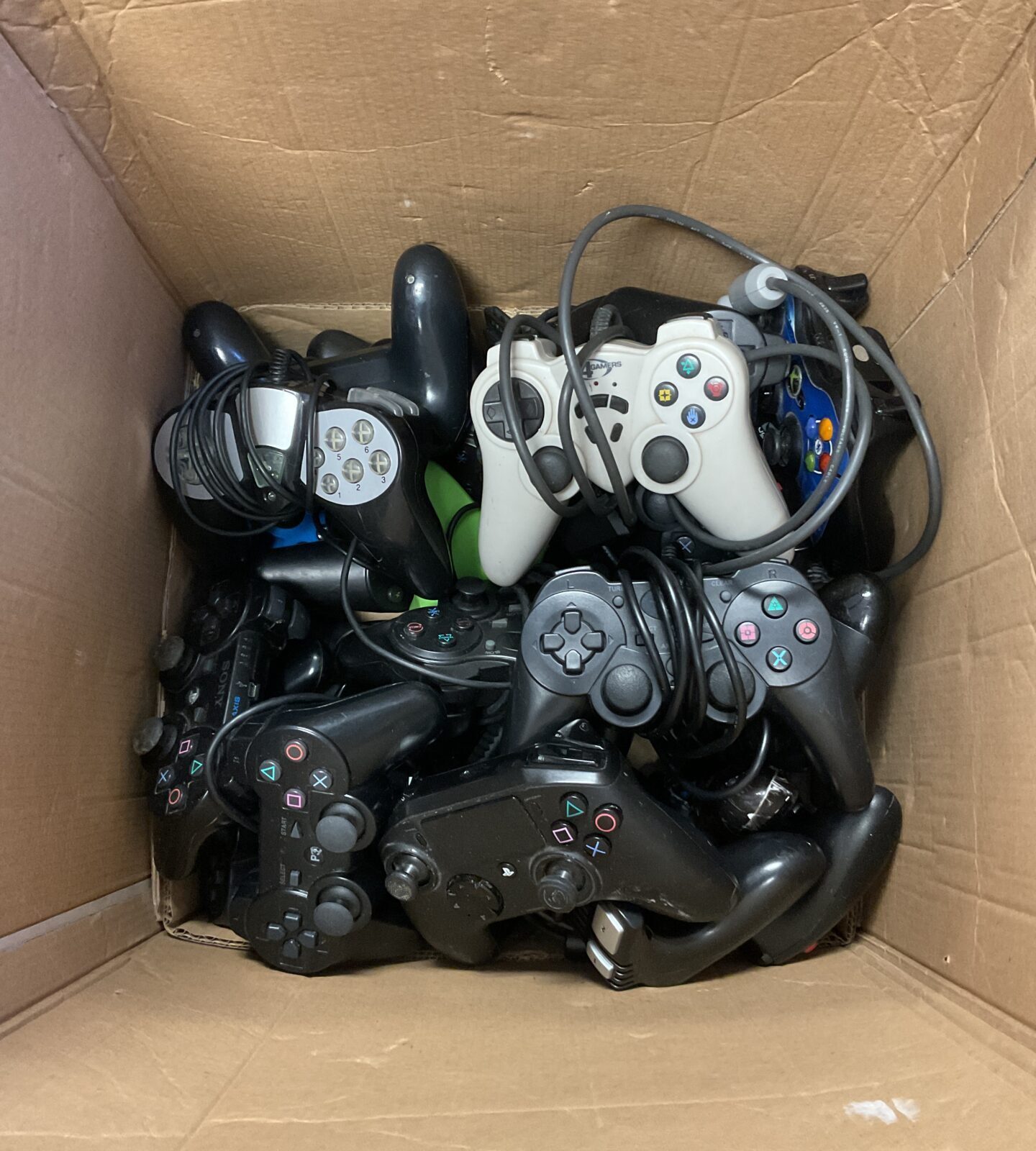 Large box of gaming controllers including PlayStation 3 & xbox