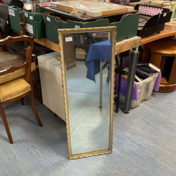 Vintage gilt framed mirror with ornate detailing.