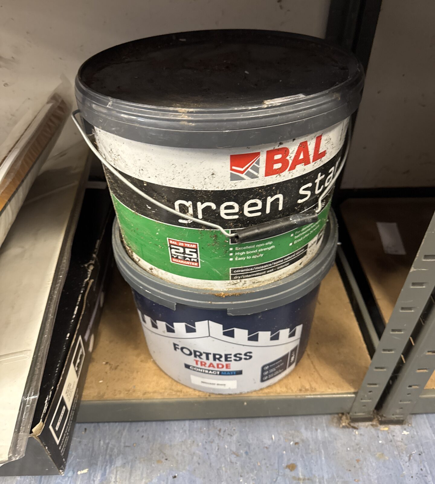 Large tub of brilliant white paint with large tub of tile adhesive - feel mostly full