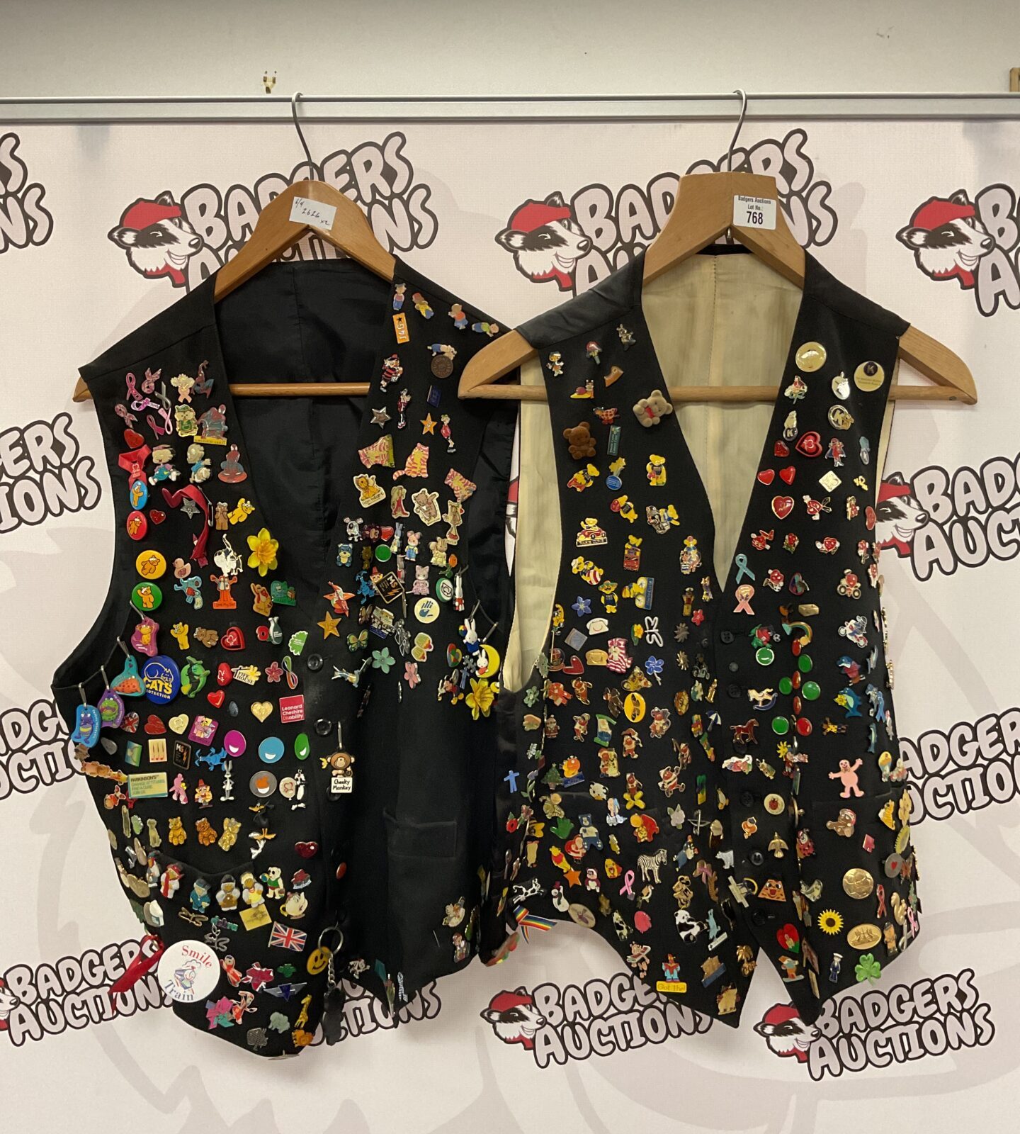 Two waist coats covered in pin badges