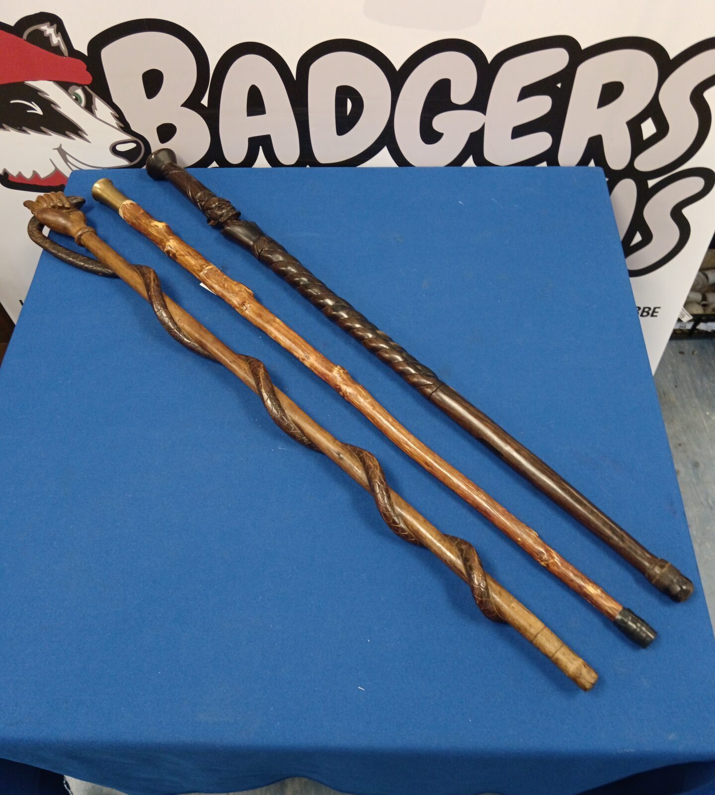 Three vintage wooden walking sticks including snake in hand stick