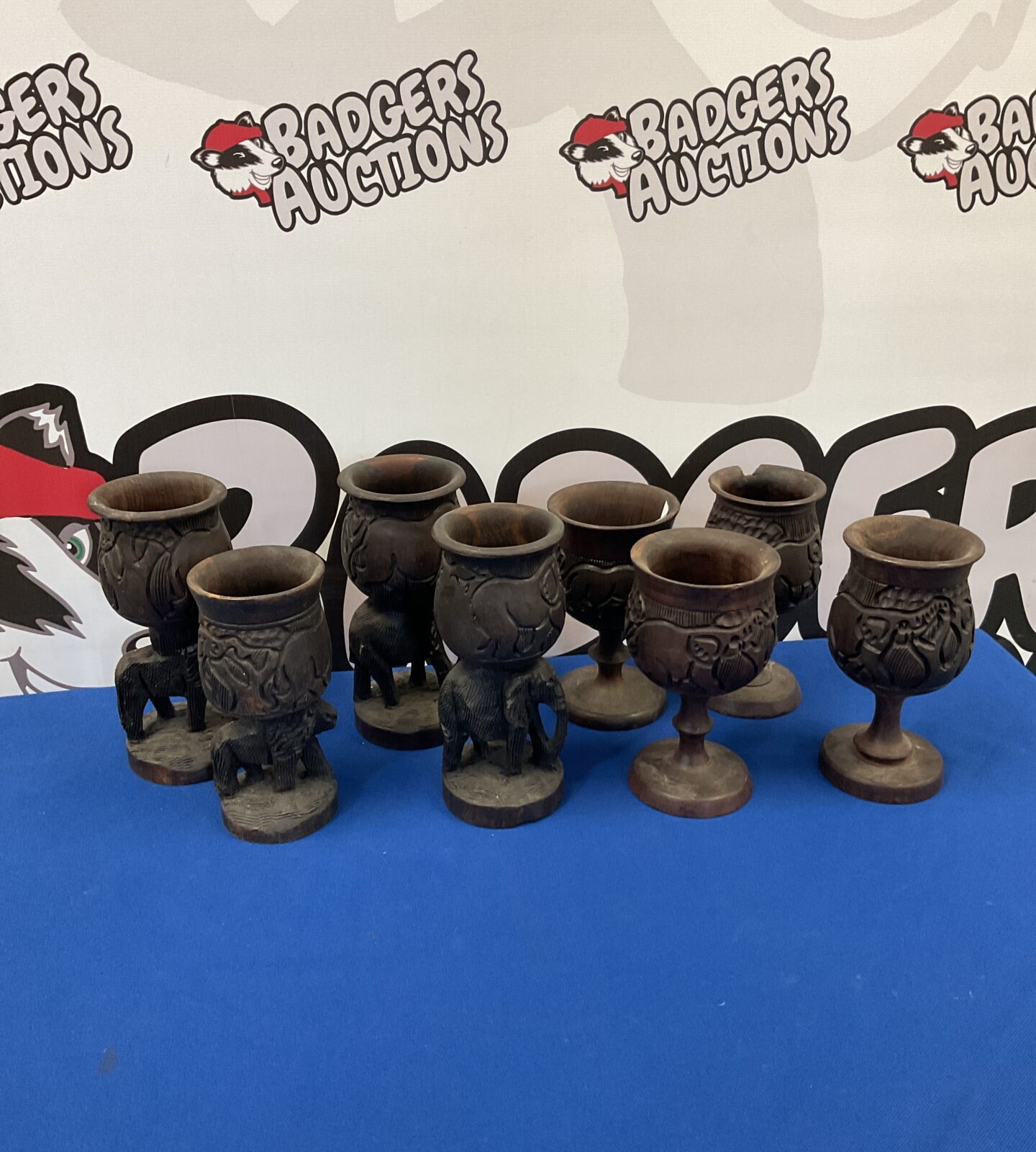Two sets of four african animals carved wood goblets