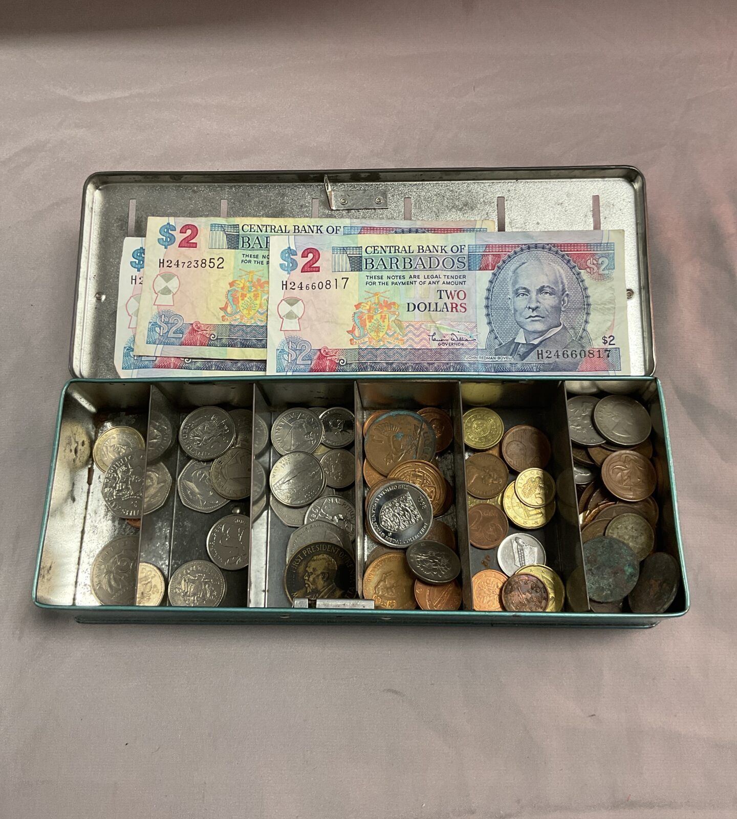 Vintage money box with assorted coins and notes