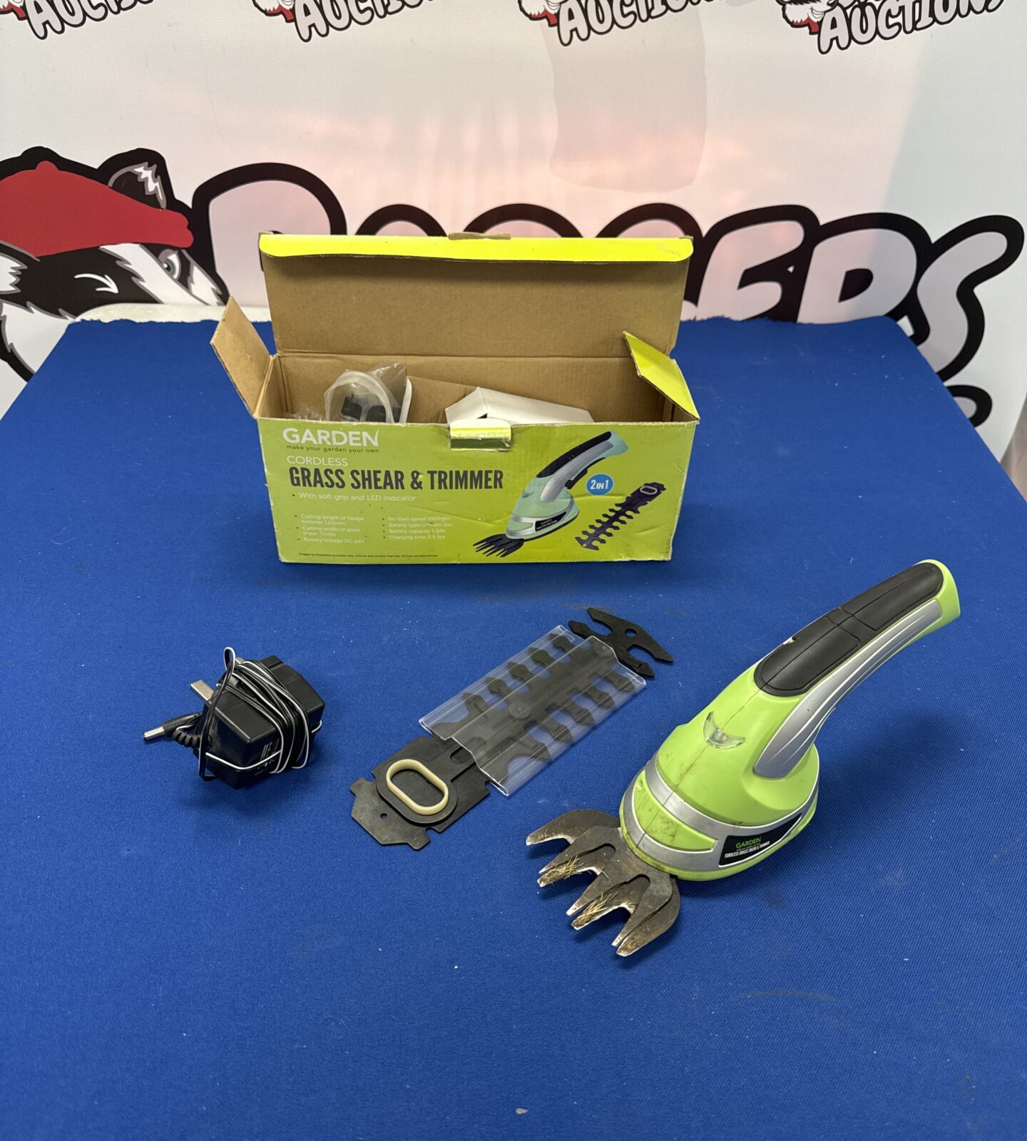 Cordless handheld garden trimmer with charger - working