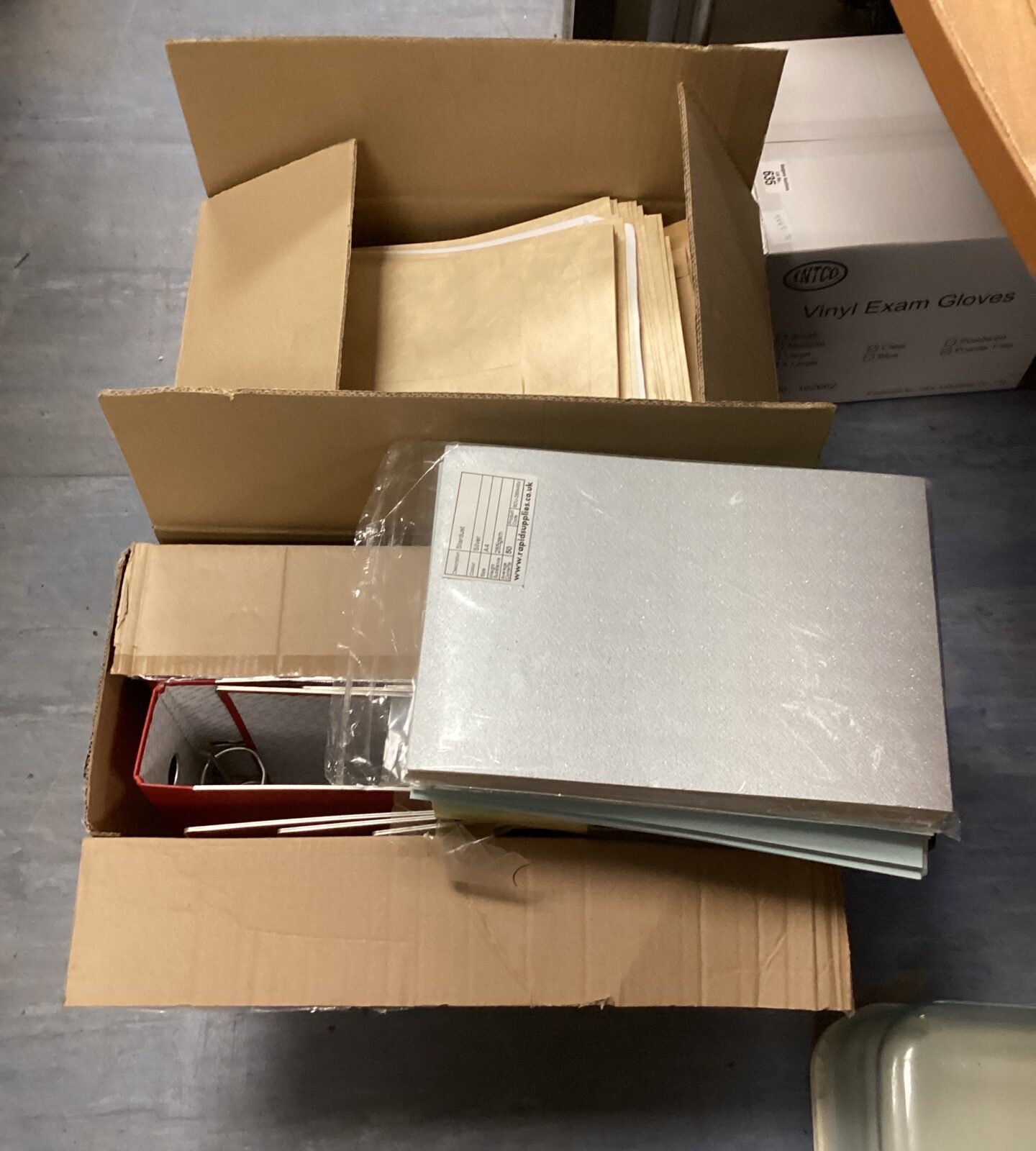 Two boxes of new stationary items inc envelopes, coloured A4 sheets of paper & ring binders