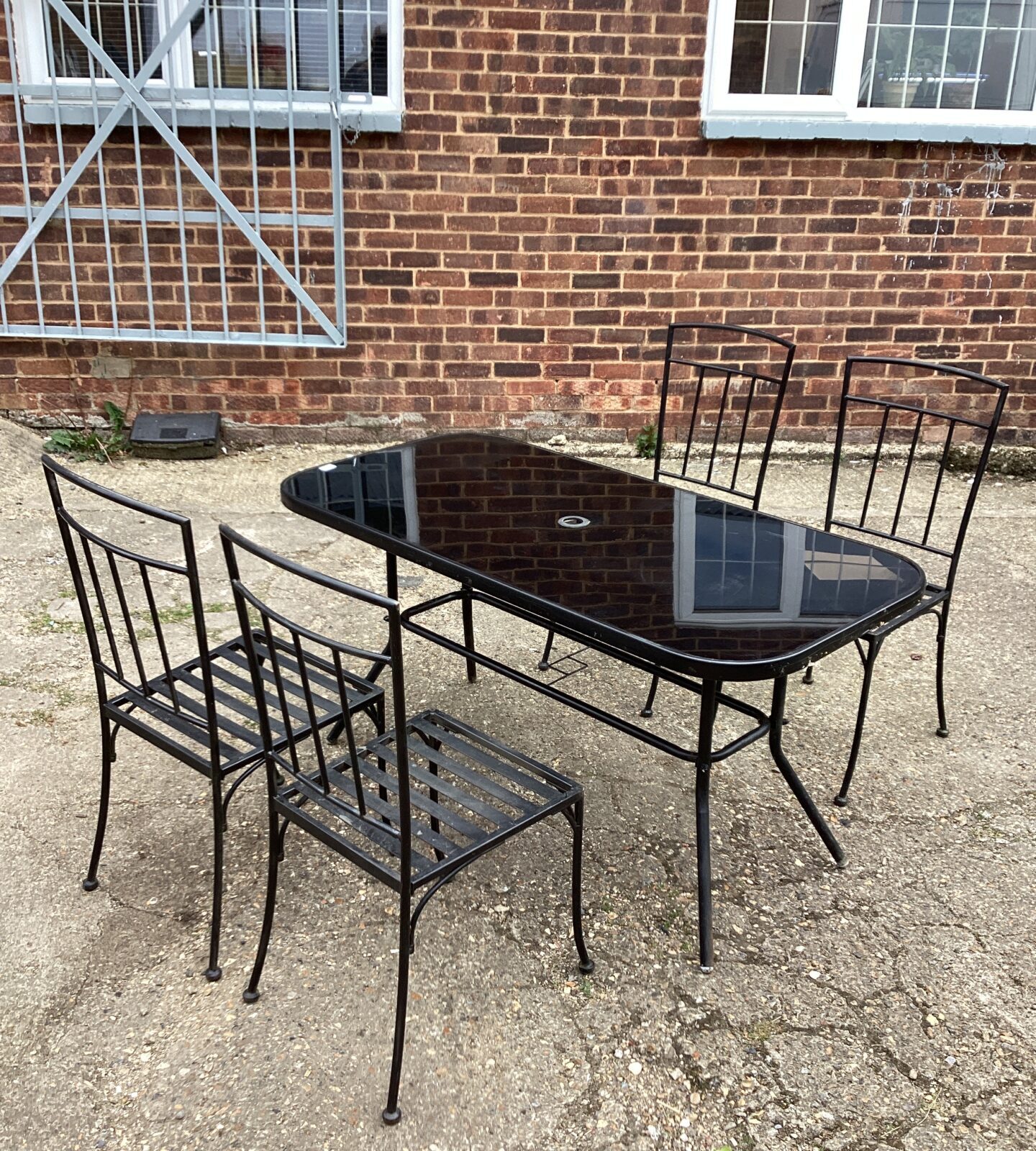 Glass topped table with four metal chairs