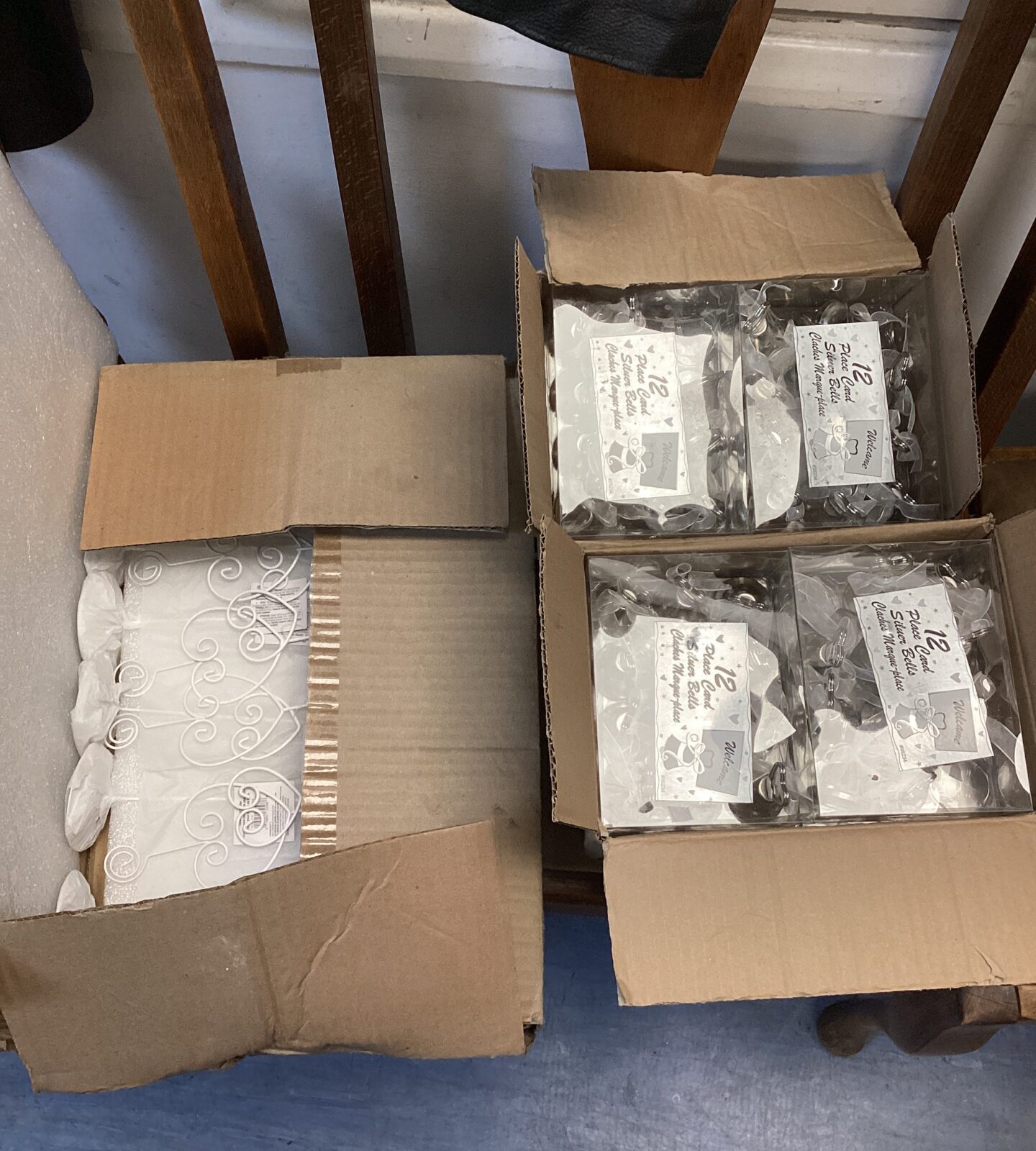 Three boxes of silver bell place card holders with stands