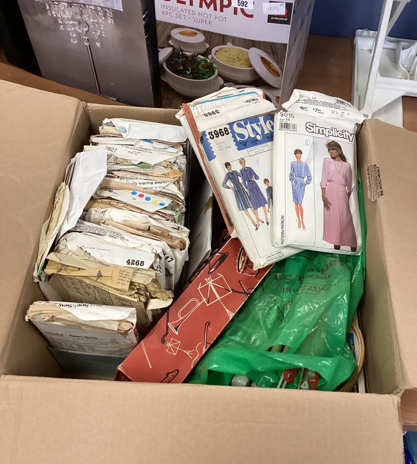 Box of sewing and knitting items with dress making patterns